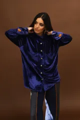 Camisa de terciopelo azul marino, de manga larga con puños abotonados y bolsillos frontales con solapa.