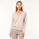 Sweater de punto fino en color beige, con escote en pico, manga larga y puños acanalados.
