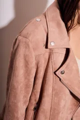 Campera tipo biker de gamuza sintética color rosa viejo, con cierre frontal cruzado, solapas con broches metálicos y bolsillos laterales con cierre.