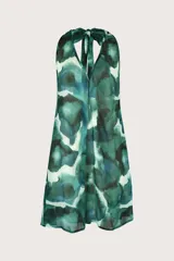Vestido corto fluido con escote halter que se ata en la nuca, y un estampado artístico abstracto en tonos verdes y azulados sobre fondo claro.