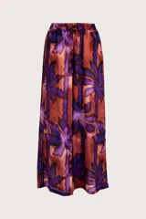 Pantalón de corte amplio y tiro alto con cintura elástica y cordón ajustable. Presenta un estampado botánico de hojas en tonos púrpuras y rojizos sobre una base cobriza, con una caída fluida y relajada.