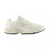Championes New Balance ML725 color crema con detalles en gris, confeccionados en malla y material sintético.