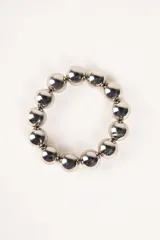 Pulsera elástica plateada con cuentas redondas grandes.