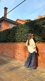 Camisa de corte oversize con estampado de cuadros en tonos grises. Presenta cuello camisero, mangas largas abullonadas y cierre frontal con botones.