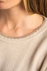 Sweater color crema con rayas horizontales en tonos marrón, bordeaux y beige.