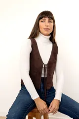 Chaleco marrón de gamuza con cordones de ajuste en el frente.