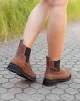 Botinetas estilo Chelsea de cuero marrón, con paneles laterales elásticos en color negro y suela track dentada de goma negra.