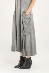 Vestido midi de satén liviano de viscosa color gris, con diseño amplio de inspiración cargo que incluye cuatro bolsillos dobles de solapa caída. Posee escote en V, breteles regulables, espalda baja y ruedo deshilachado.