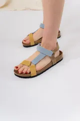 Sandalias con base anatómica de corcho y suela antideslizante. Presentan tiras de cuero suave combinadas en tonos pastel y tierra, y cierre adherente regulable.