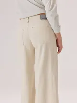 Pantalon de corte ancho y tiro alto, confeccionado en una mezcla de fibras naturales. Presenta un diseño de pierna recta y holgada, con bolsillos traseros aplicados y costuras reforzadas a lo largo de la pierna.