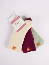 Pack de tres pares de medias acanaladas de largo medio en color crema, borgoña y verde claro. Cada par tiene un pequeño logo de la marca en el tobillo.