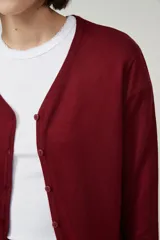 Cárdigan color beige con escote en V y cierre frontal con botones.