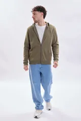 Campera deportiva verde con capucha, cierre frontal completo, bolsillos tipo canguro y puños y cintura elásticos acanalados.