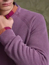 Sweater de punto en color azul marino, con cuello redondo y mangas raglán. Presenta un tejido acanalado fino y puños elásticos.