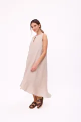Vestido midi azul marino sin mangas, con escote redondo y detalle de abertura en forma de lágrima en el pecho. Diseño holgado con corte asimétrico y volado en el ruedo.