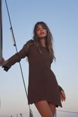 Blusa de punto larga color rojo con destellos dorados, manga larga, escote bote y pequeñas aberturas en los laterales y puños.