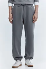 Pantalón deportivo de felpa con interior cepillado, corte relajado, cintura elástica con cordón de ajuste, bolsillos laterales y puños acanalados en los tobillos.