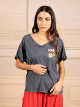 Remera gris con efecto lavado, escote en V y mangas cortas con dobladillo. Estampado frontal con la palabra 'Martini' en rojo y blanco, y un dibujo de un vaso de Martini con aceituna.