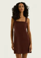 Vestido corto marrón con escote cuadrado y tirantes anchos, corte recto y holgado.