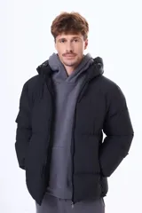 Campera puffer negra con capucha, cierre frontal y puños elásticos. Diseño acolchado con relleno térmico y exterior de nylon resistente.