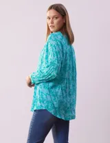 Blusa de gasa estampada con flores, marca Grand & Greene. Tiene cuello a la base, escote en V y abertura con botones.