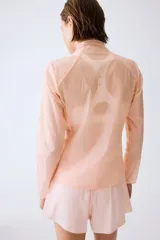 Campera de correr liviana color salmón, de corte estándar con cuello elevado, cierre frontal y tecnología DryMove para absorber el sudor.