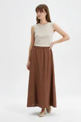 Falda larga de algodón color marrón, con cintura elástica con punto smock y caída amplia.