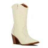 Bota de caña alta estilo western color crema, con costuras decorativas en el cuerpo, taco cuadrado de madera y punta fina con detalle metálico.