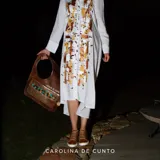 Vestido camisero blanco de manga larga, confeccionado en viscosa, con diseño largo y frente intervenido con arte abstracto pintado a mano en tonos dorados y marrones por la marca Carolina De Cunto.
