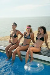 Conjunto de bikini plateado de lycra morley metálica, con corpiño triángulo con breteles para anudar y regular, y bombacha vedetina con reguladores metálicos.