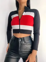 Top manga larga con cierre frontal y diseño tricolor con franjas horizontales en negro, blanco y rojo, fucsia, violeta o azul.