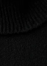 Vestido corto de punto con cuello alto y manga larga, de diseño recto y estilo minimalista.