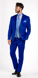 Traje de vestir compuesto por chaqueta y pantalón en color azul cobalto. La chaqueta presenta solapas en punta de raso al tono, cierre de un botón y bolsillos de doble vivo. El pantalón es de corte recto y diseño formal.