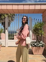 Bandolera compacta color rojo con textura de cuero, correa regulable y desmontable con diseño de rayas rojas y blancas. Cuenta con bolsillos frontales y cierre, interior forrado en tela.