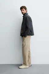 Pantalón de corte recto confeccionado en tejido de sarga con estructura diagonal. Presenta cintura elástica, bolsillos delanteros, bolsillos traseros de vivo y cierre frontal con cremallera y botón.