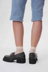 Zapato mocasín de cuero negro con cordones, plataforma y taco cuadrado.