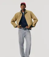 Pantalón de jean corte recto en color gris, con diseño clásico de cinco bolsillos, cierre frontal con botón y cremallera, y trabillas para cinturón.