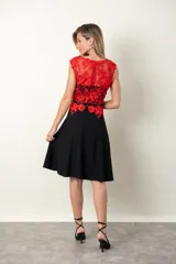 Vestido midi con falda negra acampanada de crepe y top rojo de tul con apliques de flores bordadas al tono. Corte en la cintura con lazo.