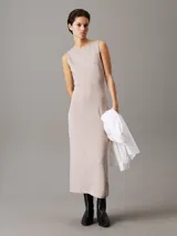 Vestido largo de punto milano color beige, sin mangas, con cuello barco, corte slim y panel trasero recortado.