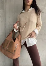 Buzo color beige de hilo con mangas largas y detalle de calado en los hombros.