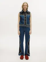 Pantalón de jean estilo oxford y tiro alto, color tostado, con apliques metalizados en forma de tachas que bordean los laterales y costuras.