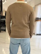 Sweater marrón de tejido de punto acanalado, con cuello polo en color marfil y cierre frontal en V. Presenta inscripciones y logotipos bordados en el pecho, incluyendo la palabra "Concept" en tipografía cursiva y "ALL GOOD FEELS" en la parte inferior.