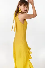 Vestido midi marrón de lino italiano, con cuello halter, sin mangas y diseño asimétrico con volados en el ruedo.