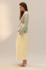 Zapato de tacón con cuerpo cubierto de lentejuelas plateadas, diseño con tira en T, cierre de hebilla en el tobillo y acabado en punta.