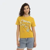 Remera amarilla de corte clásico con estampado de paisaje playero con palmeras, cabaña y la frase "Welcome to Malibu. Reef Beach Club".