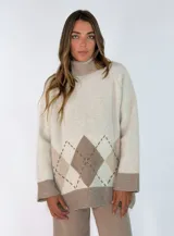 Sweater de cuello alto con diseño de rombos en tonos beige y crema, de corte holgado y mangas largas con puños anchos.
