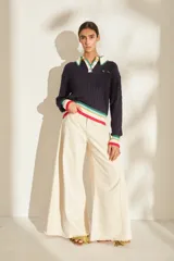 Buzo de punto azul marino con cuello polo blanco y detalles de rayas de colores en el cuello, los puños y el ruedo. Cuenta con cierre frontal parcial de botones y diseño tejido de ochos.