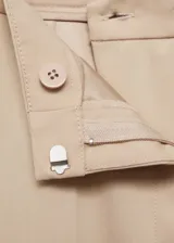 Pantalon de vestir de corte recto y tiro medio, con diseño clásico de traje. Cuenta con trabillas para cinturón, dos bolsillos laterales y dos bolsillos de ribete en la parte posterior, con terminación de botamanga con dobladillo.