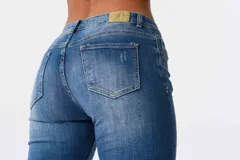 Jeans de corte ajustado y tiro medio en color azul, con detalles de bordados florales coloridos en una de las piernas.