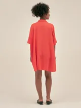 Túnica corta de lino color naranja, con cuello camisero y escote en V. Mangas cortas y corte holgado.